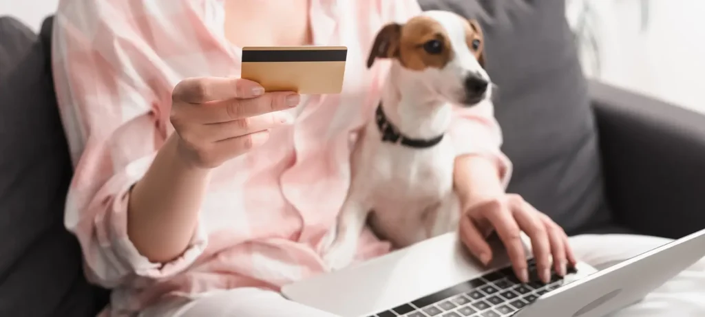 Woman with dog and holding a credit card